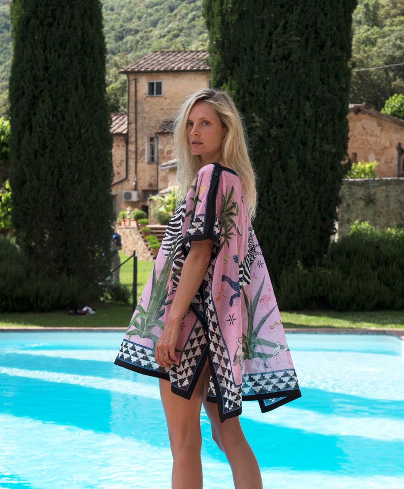 Frau im rosa rosé / bunten Strandkleid am Pool