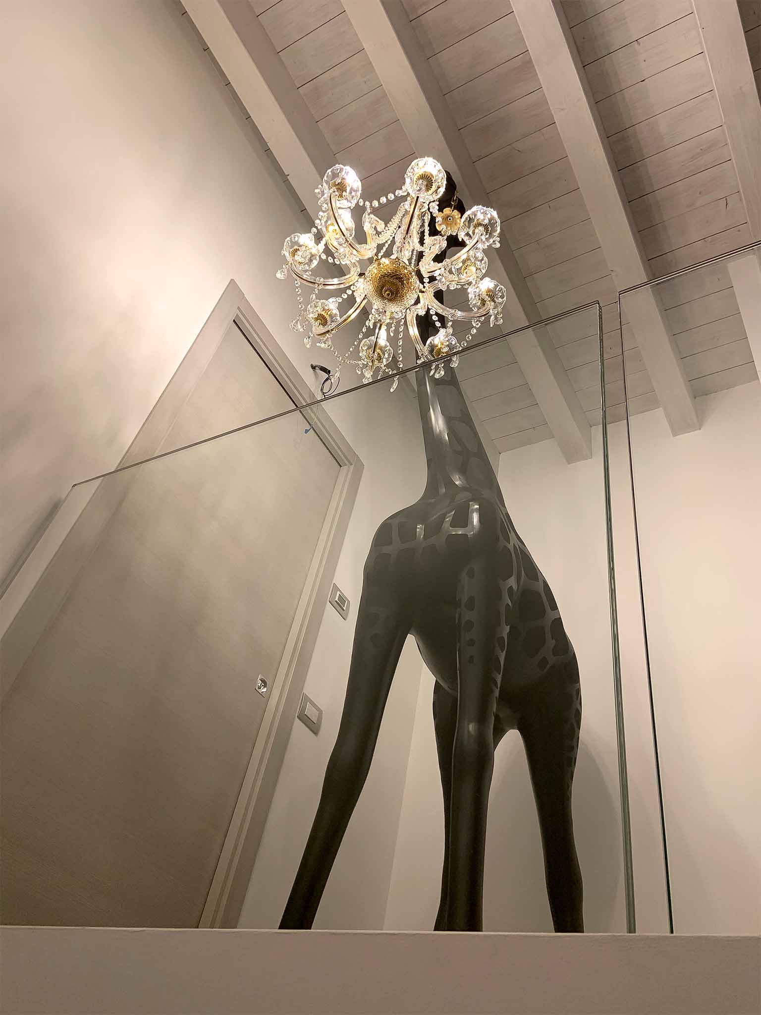 Stehleuchte GIRAFFE IN LOVE INDOOR im Wohnraum, Sicht auf Kronleuchter