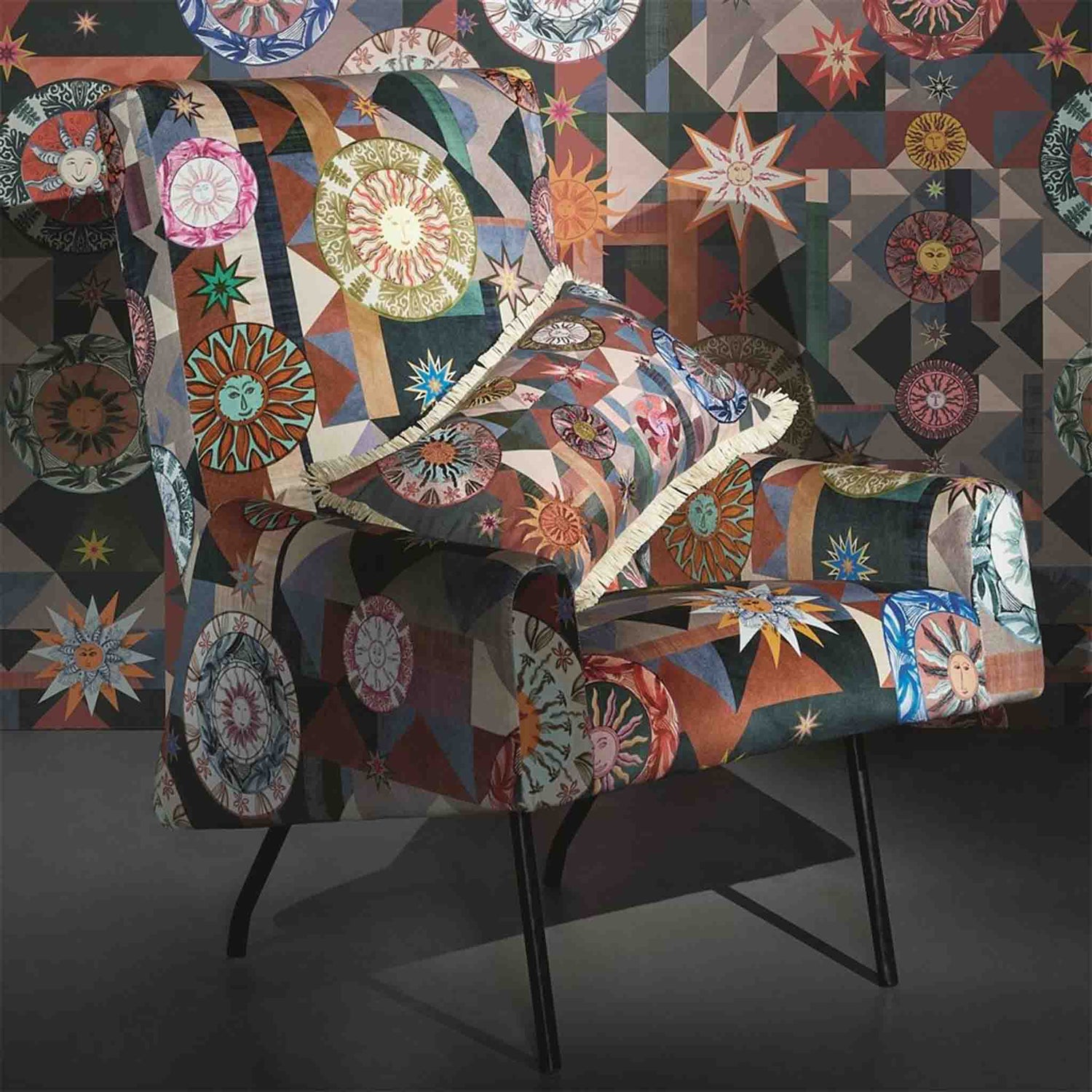 Kissen im Design von Christian Lacroix mit Sonnen und grafischen Elementen auf einem Stuhl mit gleichem Muster