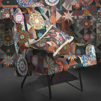Kissen im Design von Christian Lacroix mit Sonnen und grafischen Elementen auf einem Stuhl mit gleichem Muster