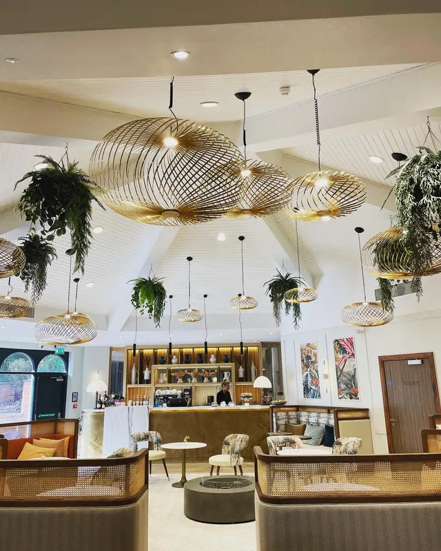 Skulpturale große Spring Design Pendelleuchte mit stark geöffneter Edelstahlstruktur in Messingoptik und zentraler LED Lichtquelle